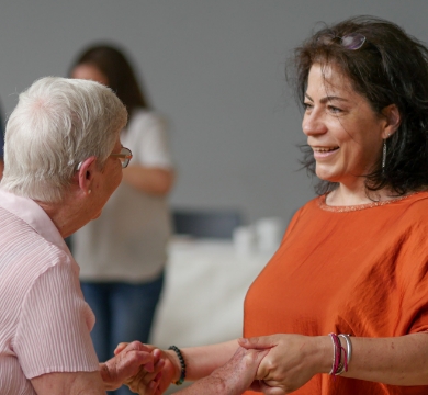 A carer holding the hand of a resident